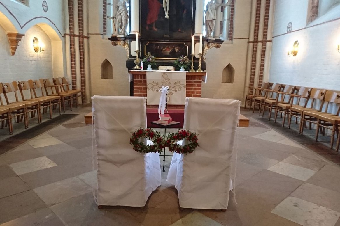 Zwei weiße Stühle vor dem Altar in der St. Johanniskirche